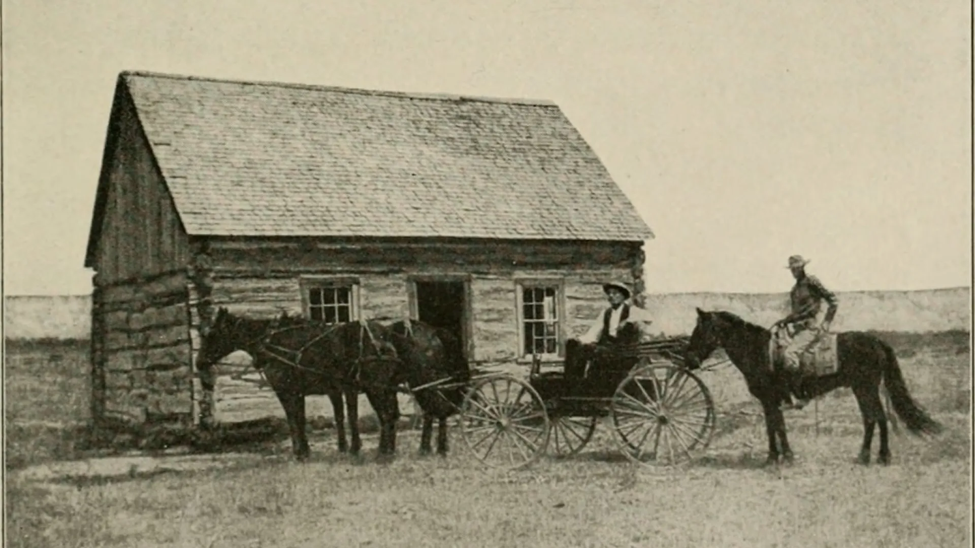 A small log cabin with a shingled roof on open prairie, a horse and buggy and a rider in front.