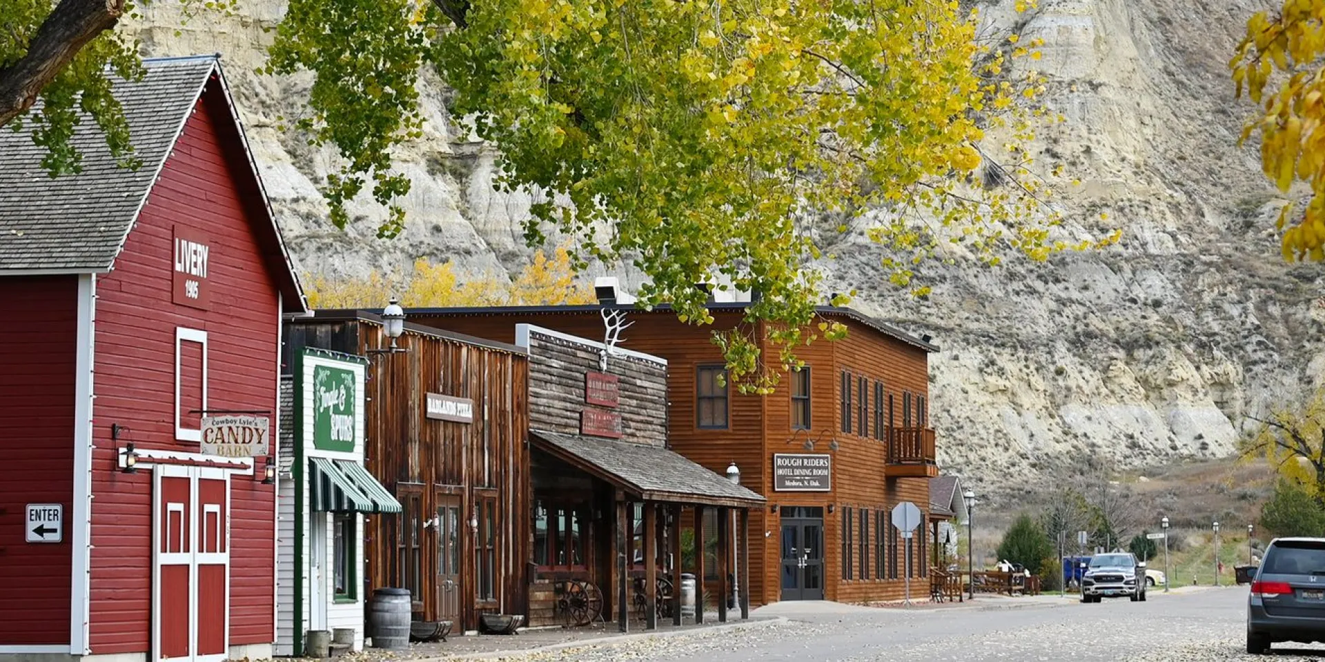 Fall color along Main Street in downtown Medora, North Dakota, with the Badlands behind.