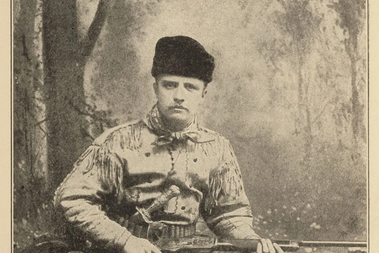 Theodore Roosevelt posing in a fringed buckskin hunting suit holding a rifle, 1885 studio portrait.