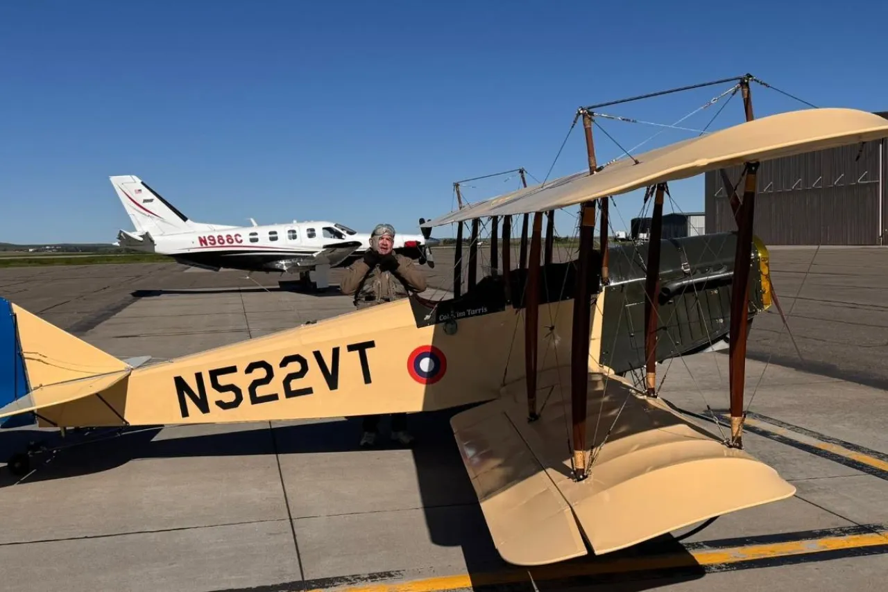A vintage Curtiss Jenny biplane and a TBM turboprop on the ramp at Dickinson Theodore Roosevelt Regional Airport