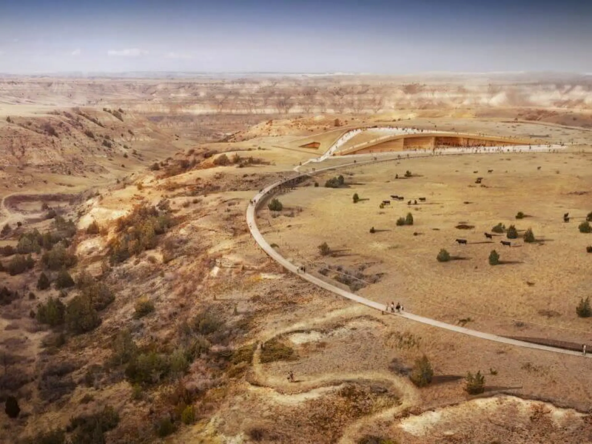 A winding road through a vast, barren desert landscape.