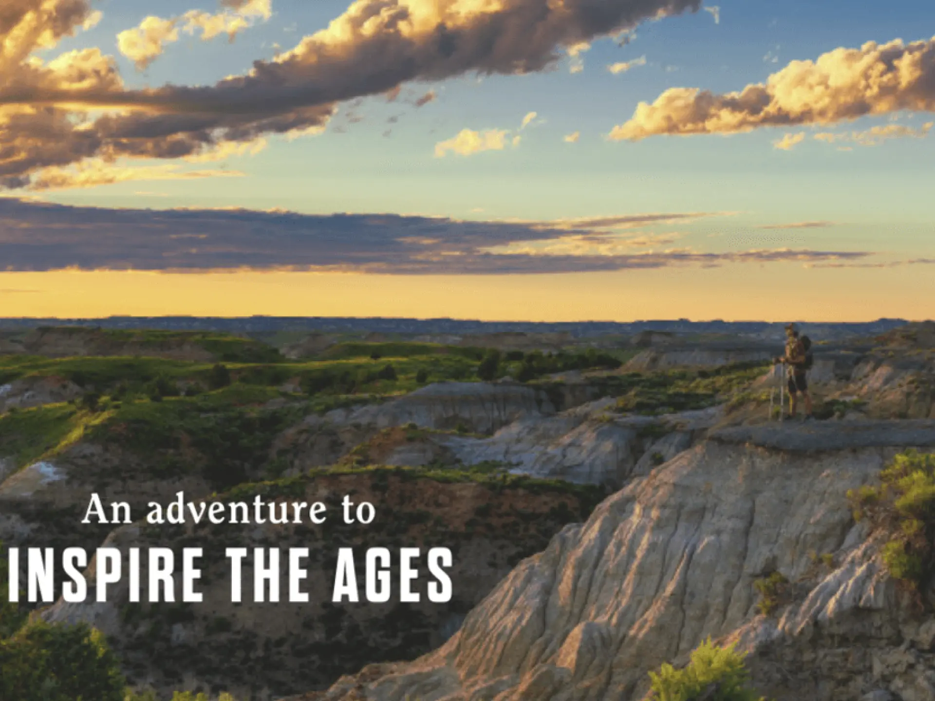 Dramatic landscape with rocky terrain under a golden sunset sky.