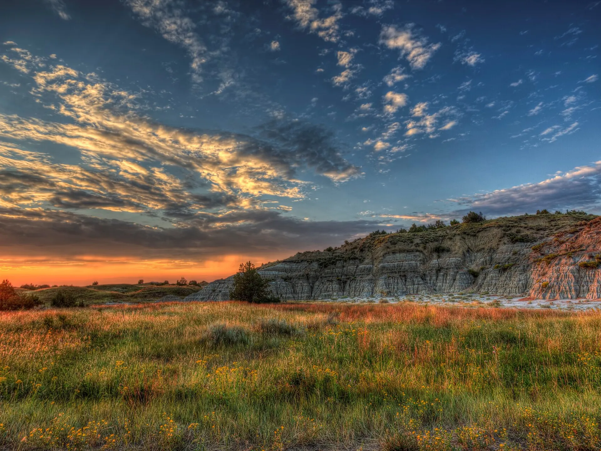 Sunset over the layered buttes and prairie grasses of the North Dakota Badlands