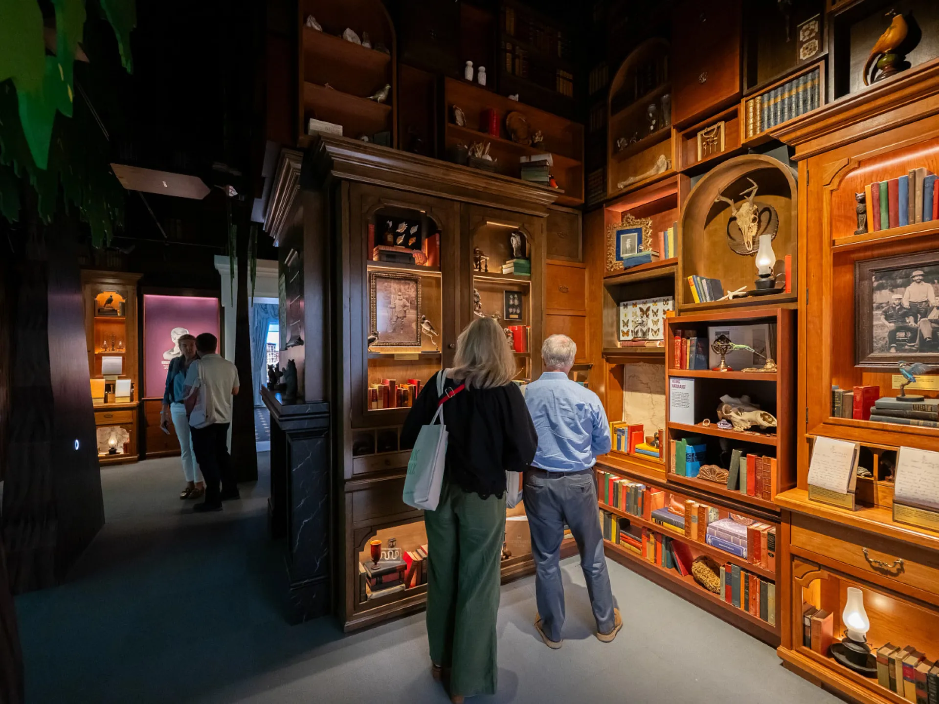 Visitors view artifacts and objects in a richly appointed gallery at the Theodore Roosevelt Presidential Library