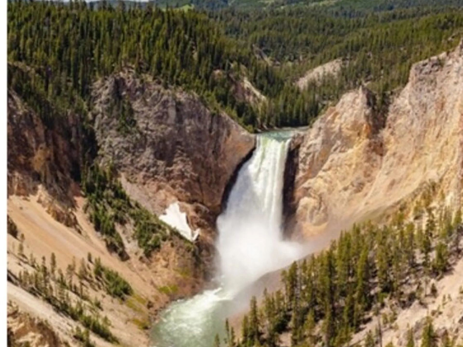 A waterfall plunging into the Grand Canyon of the Yellowstone between steep canyon walls