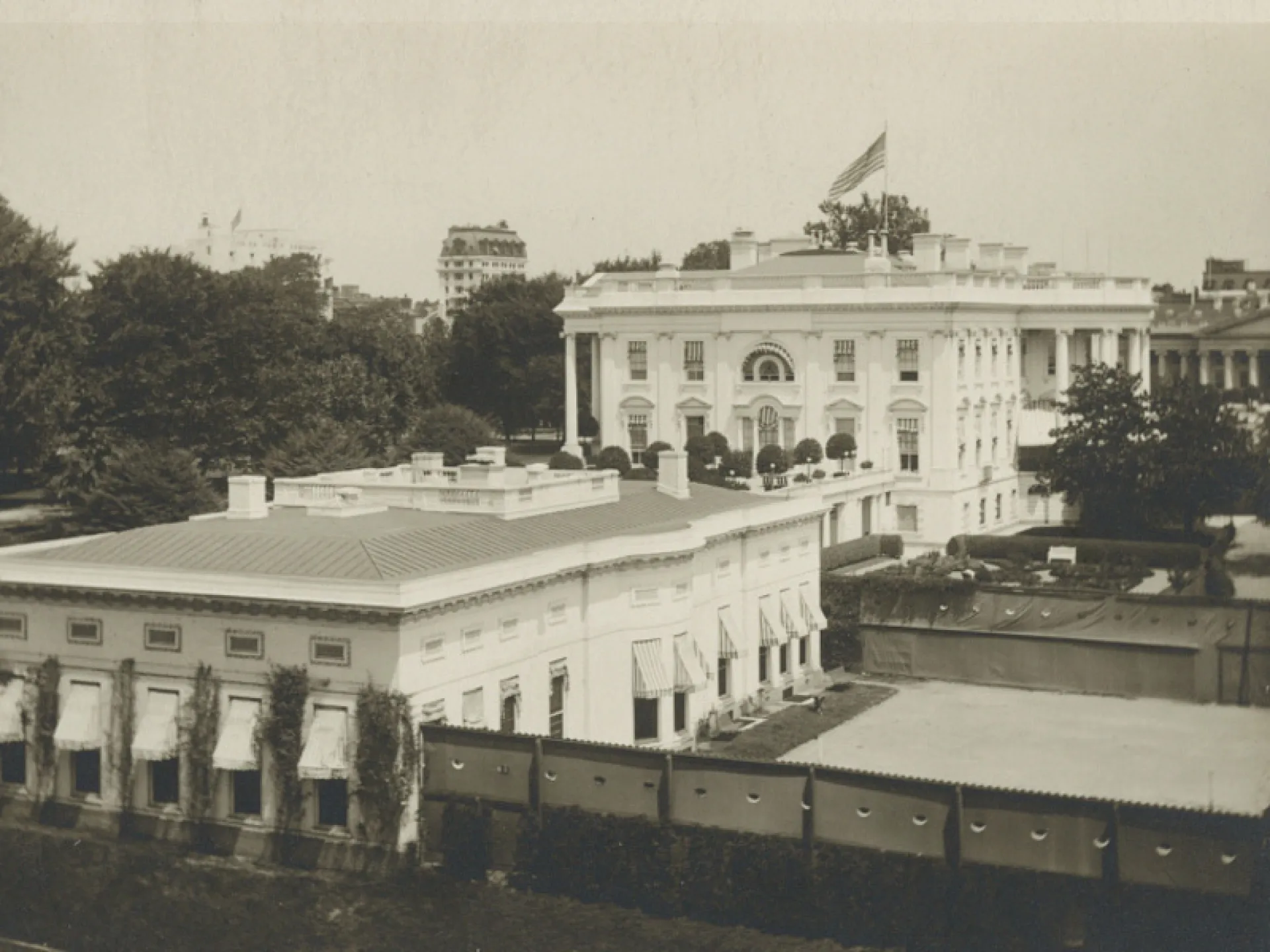 The White House and executive office building with the tennis court on the grounds, early 1900s