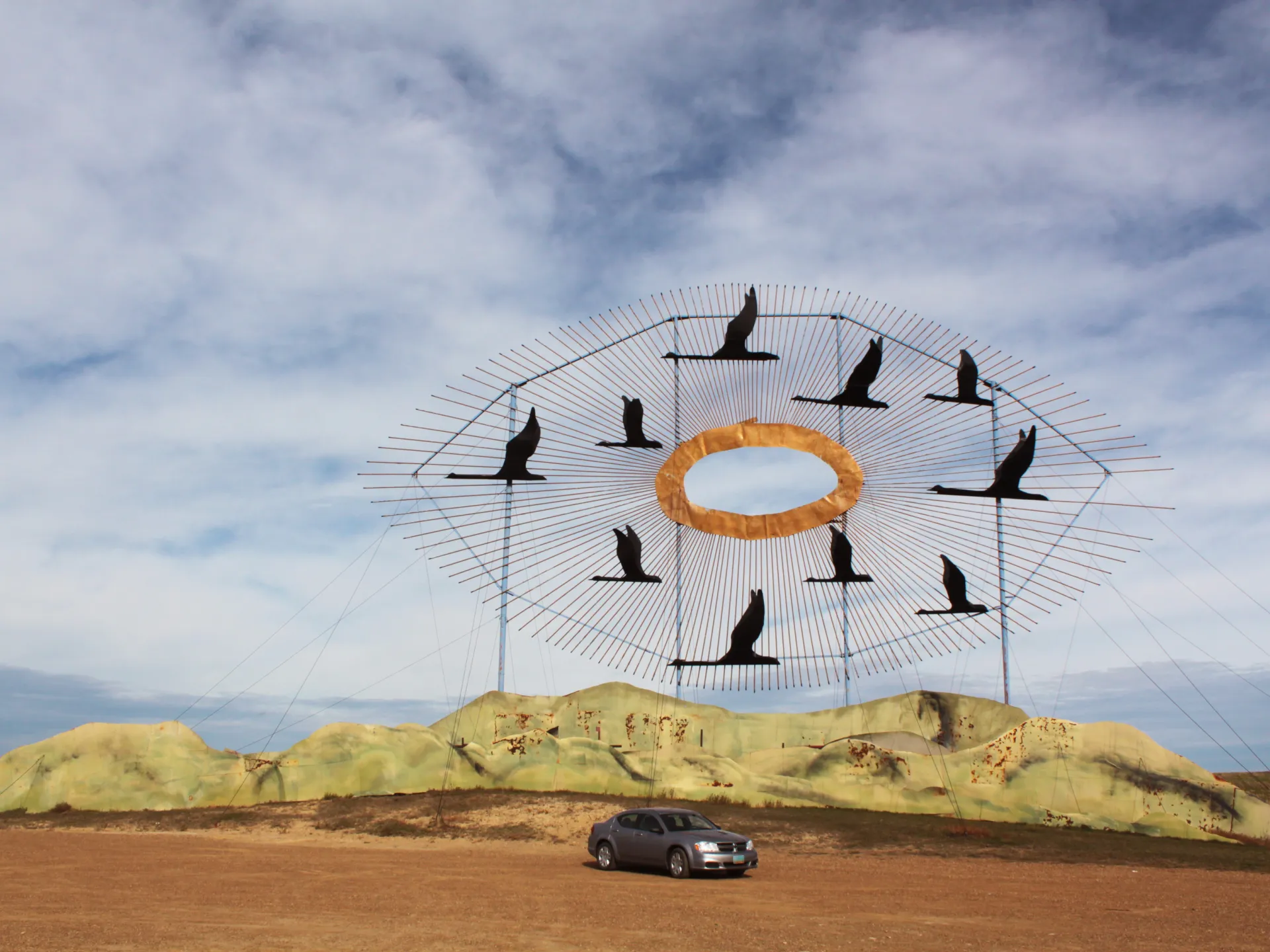 Geese in Flight, the giant scrap metal sculpture at the north end of the Enchanted Highway, with a car parked below for scale