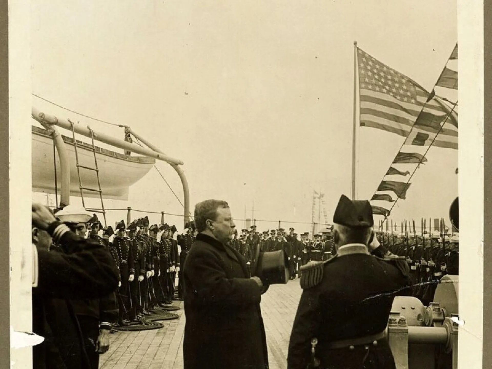 President Roosevelt reviewing sailors aboard a battleship
