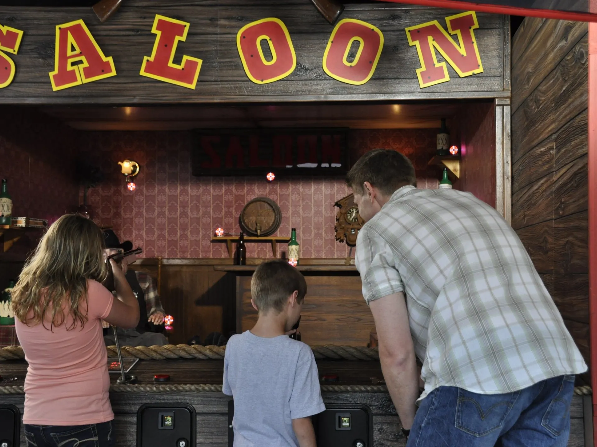 Family aiming at targets in the saloon-style shooting gallery