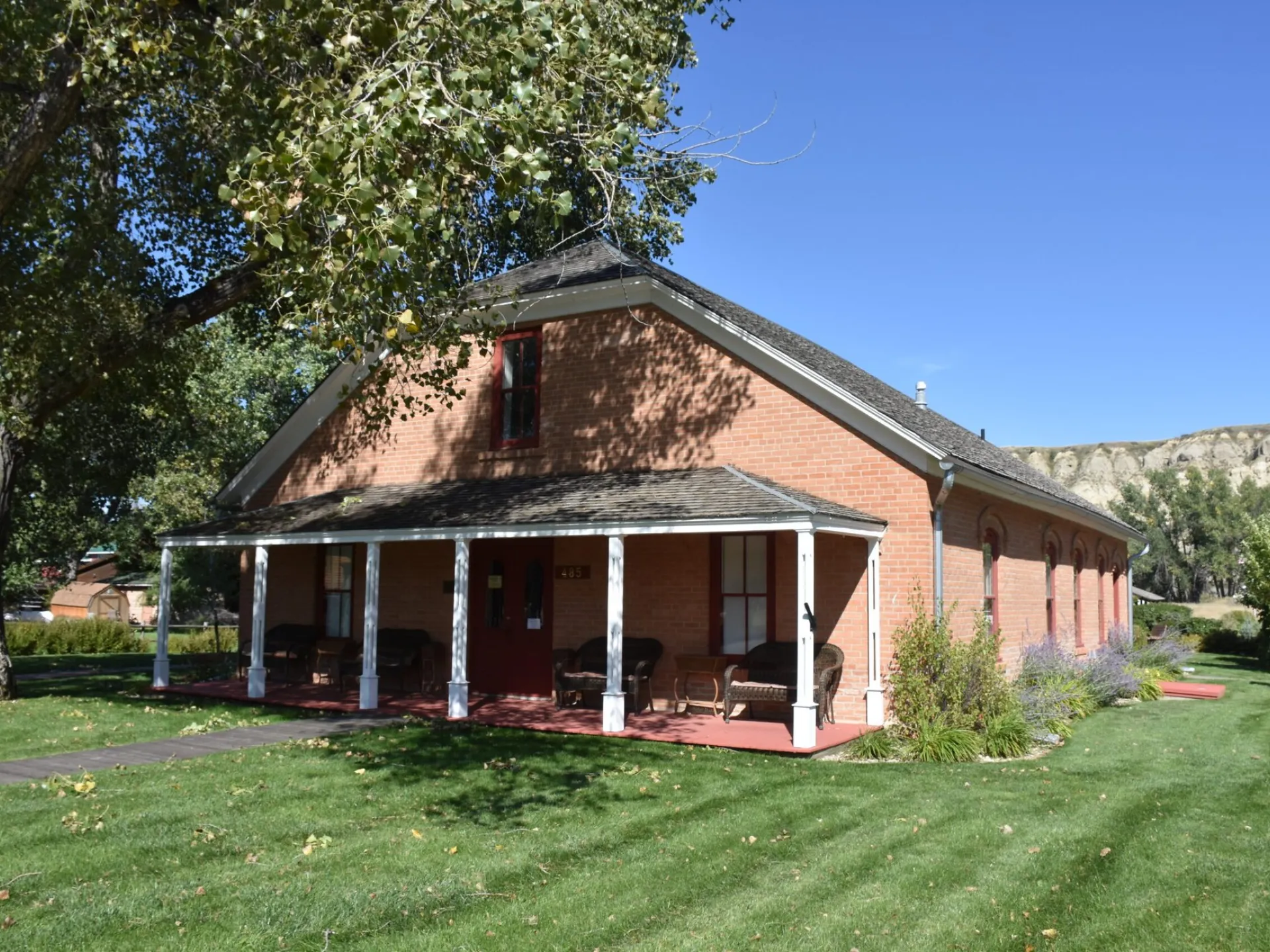 Brick Von Hoffman House with its front porch on a summer day