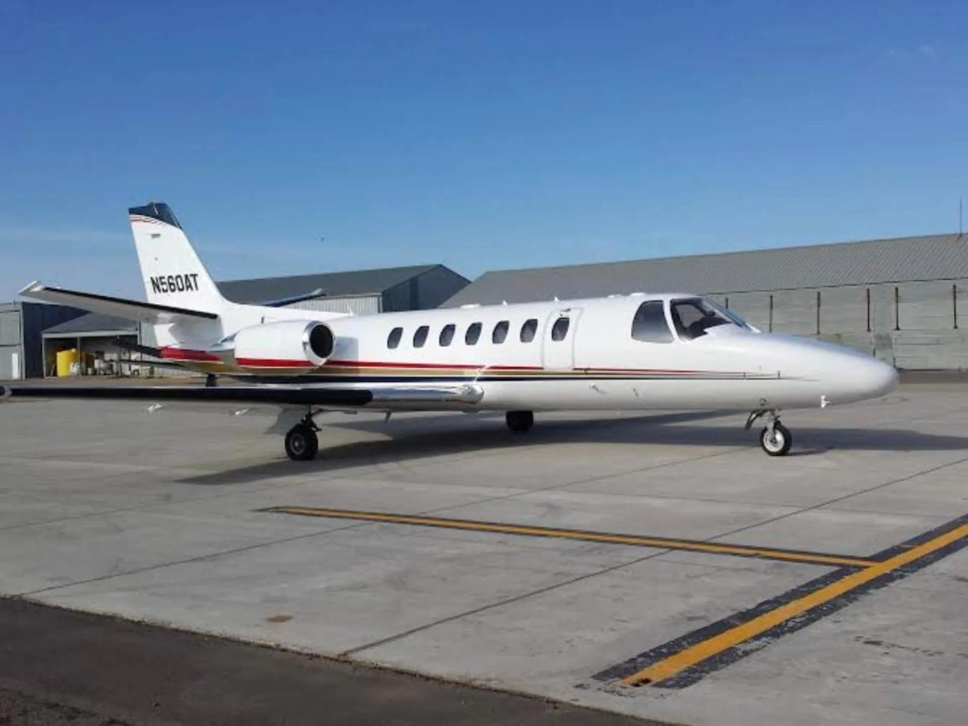 A Cessna Citation business jet parked on the ramp in front of hangars at Watford City Municipal Airport
