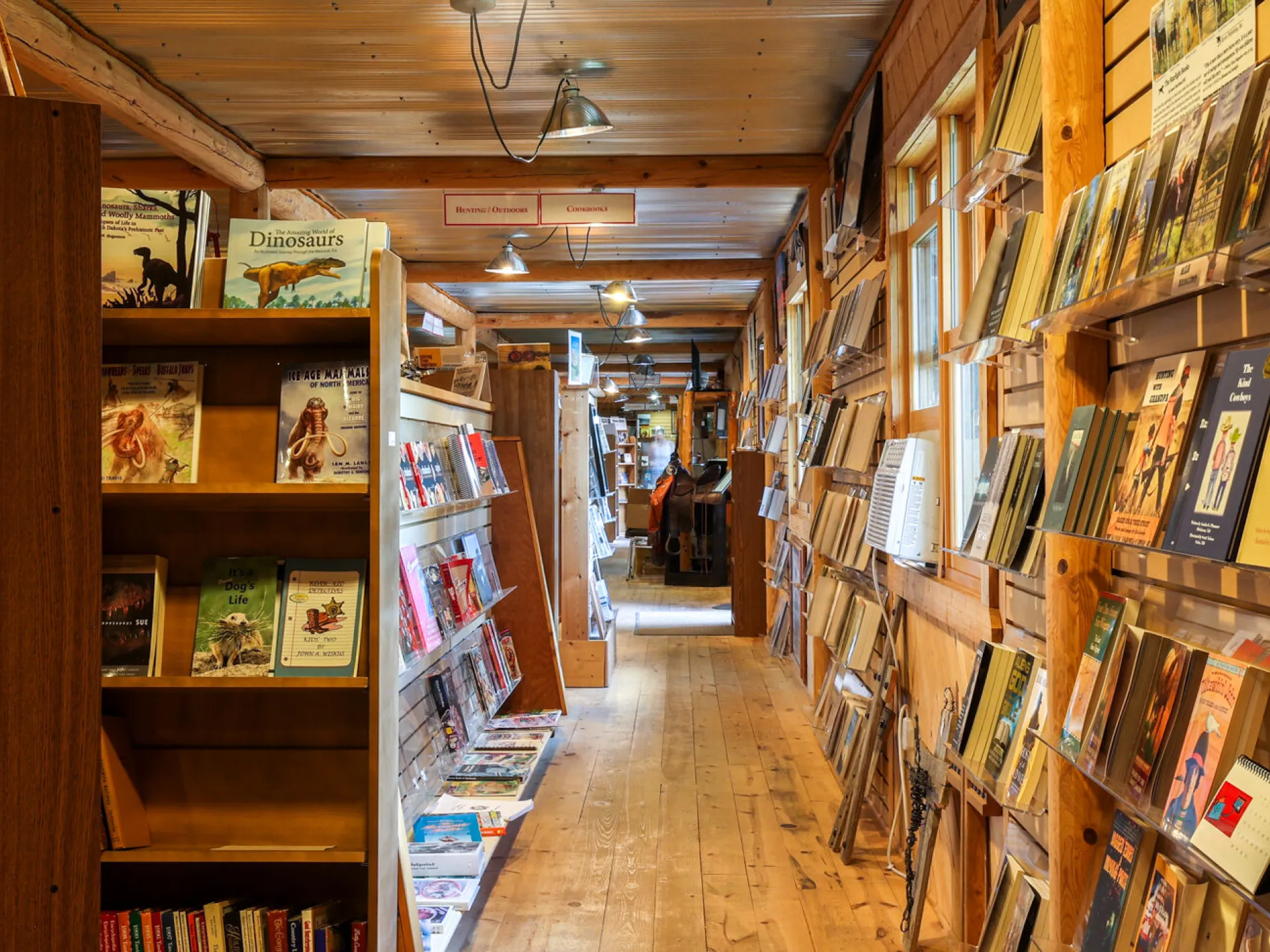 Wood-paneled aisle of Western Edge Books lined with Western and regional titles