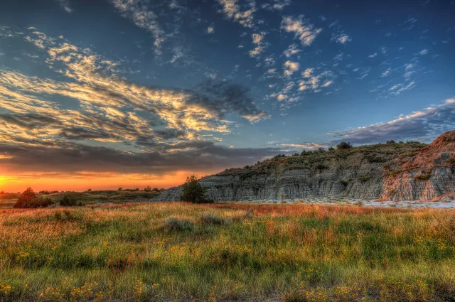 Sunset over the layered buttes and prairie grasses of the North Dakota Badlands