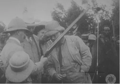Roosevelt on safari looking at firearm