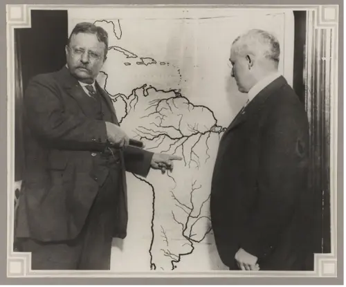 Photograph of Theodore Roosevelt with map of South America pointing at the River of Doubt