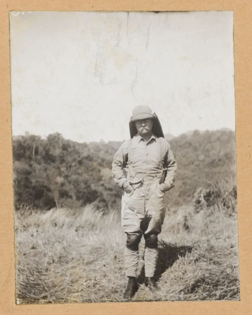 Theodore Roosevelt in safari uniform and pith helmet standing in African grassland