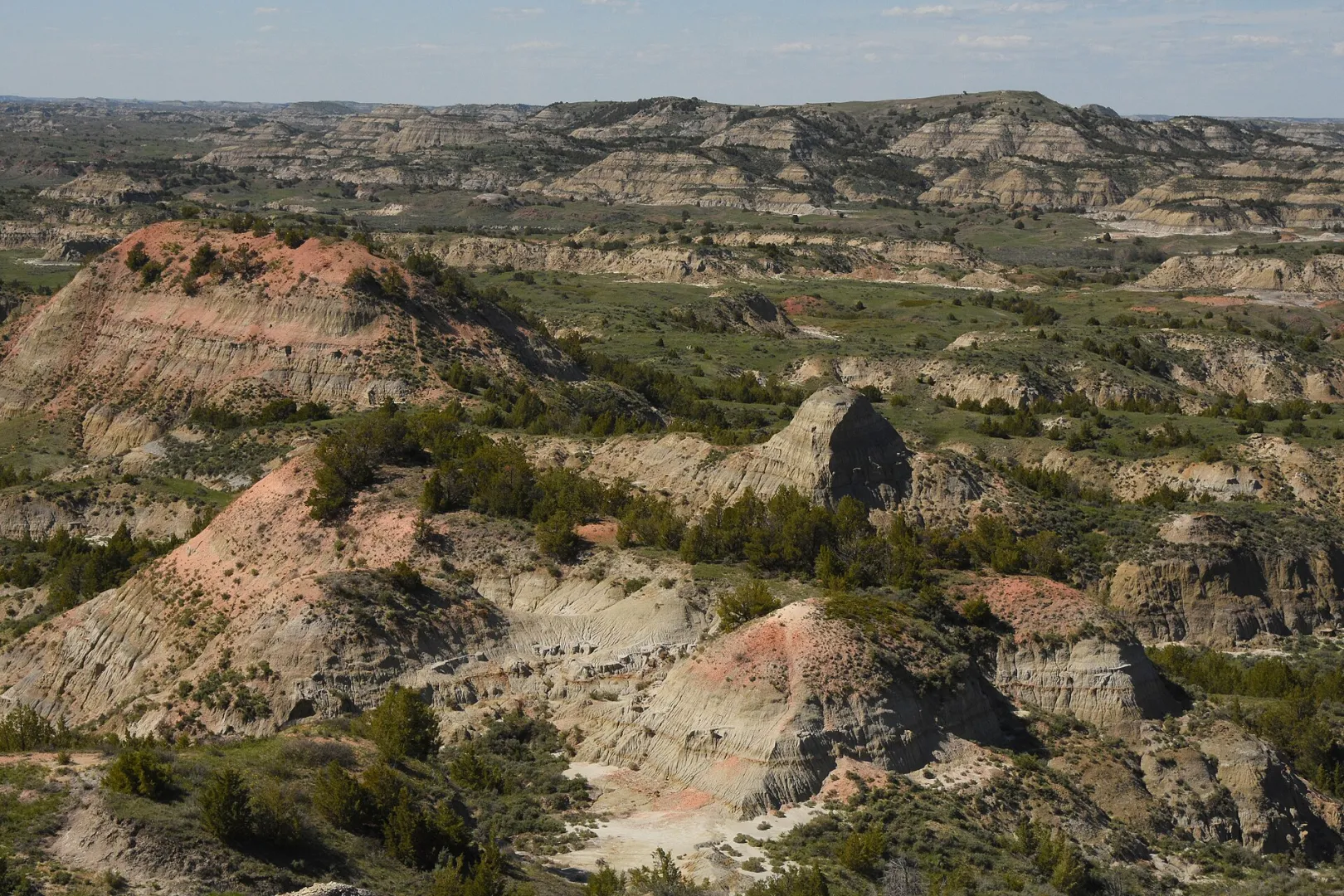 Layered red and tan buttes of the North Dakota Badlands under a wide sky