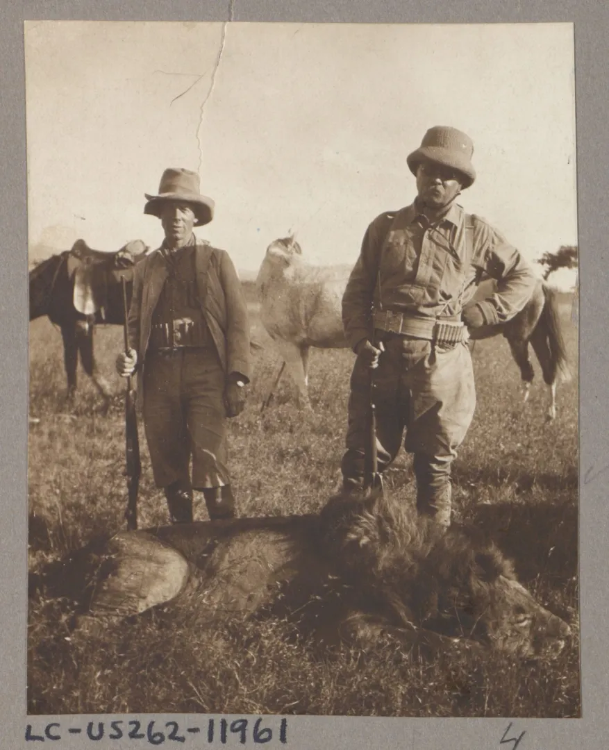 Theodore Roosevelt and hunter Leslie Tarlton standing beside a lion during an African hunt