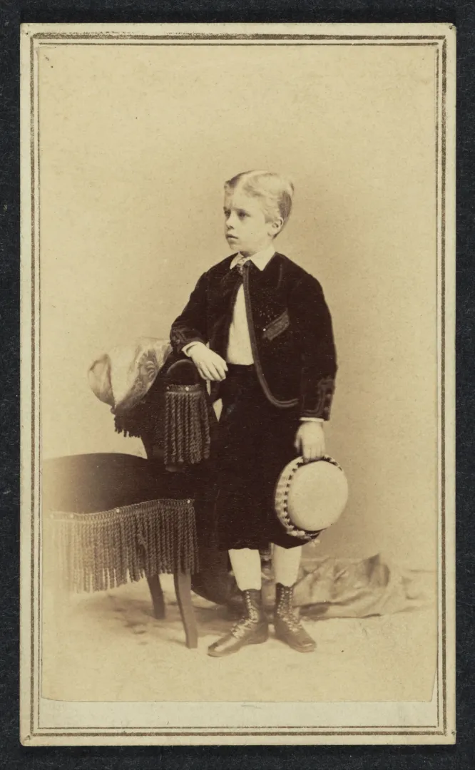 Carte-de-visite portrait of Theodore Roosevelt as a young boy standing beside a chair