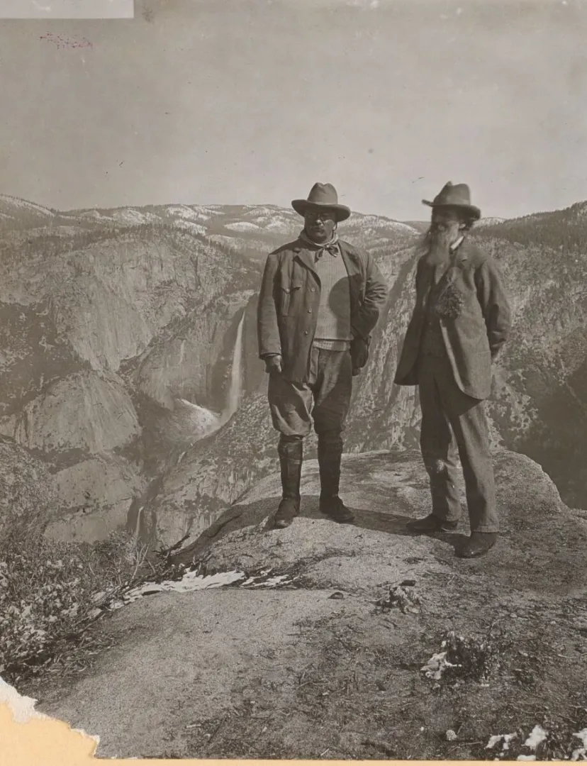 Theodore Roosevelt and naturalist John Muir standing on a rocky overlook at Glacier Point in Yosemite