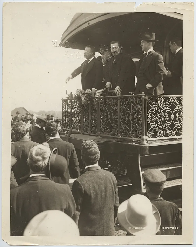 President Theodore Roosevelt addressing a crowd from the rear platform of a railroad observation car