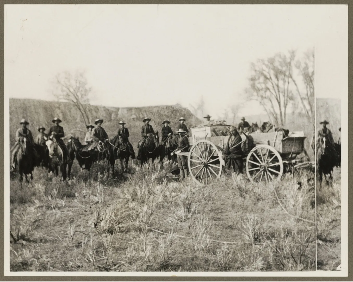 Mounted cowboys and wagons gathered on the open range during a Badlands cattle roundup