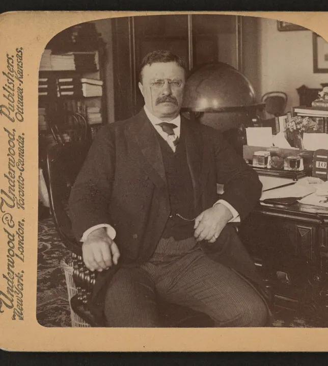 President Theodore Roosevelt seated at his desk in his White House office, about 1903