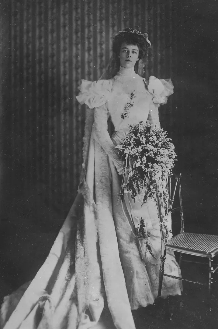 Eleanor Roosevelt standing in an elaborate white lace wedding gown holding a bouquet, 1905
