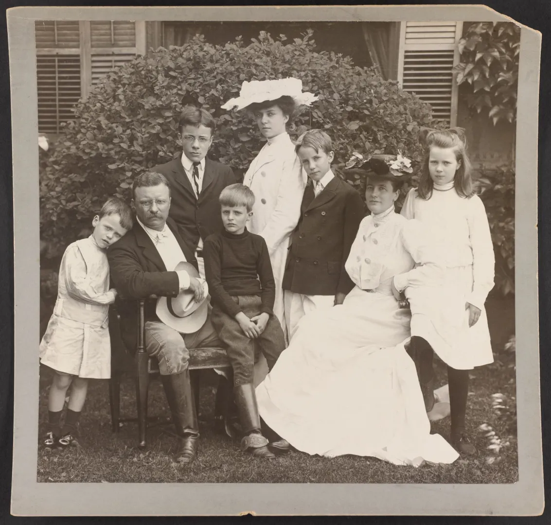 President and Mrs. Theodore Roosevelt seated on a lawn surrounded by their children, 1903
