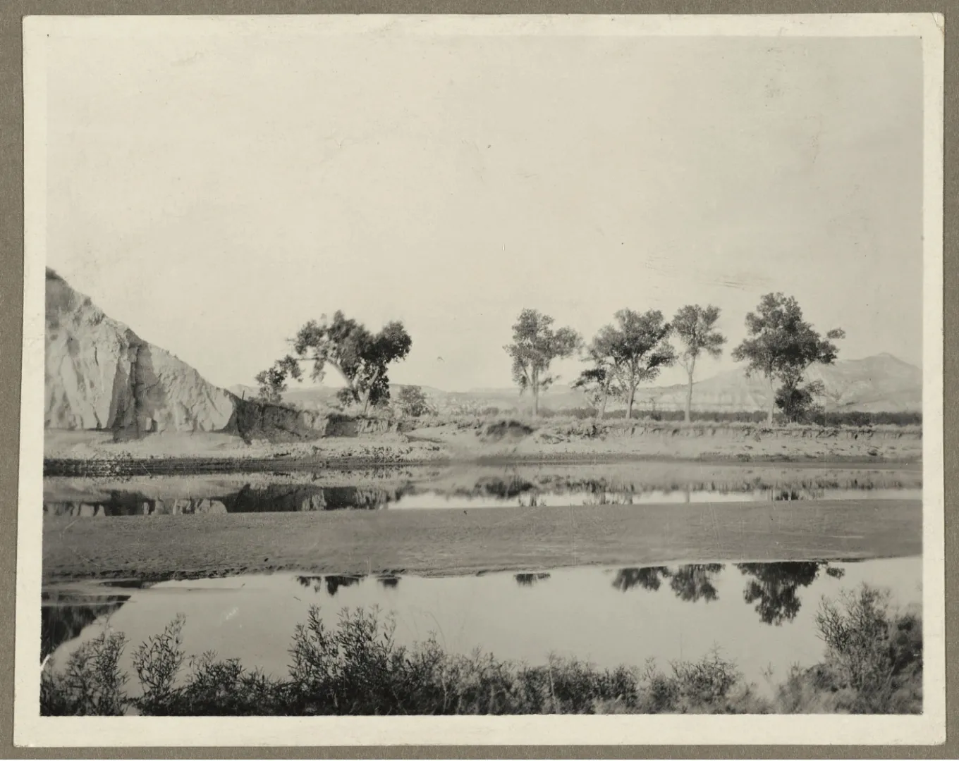 A quiet ford of the Little Missouri River with buttes and cottonwoods in the Badlands