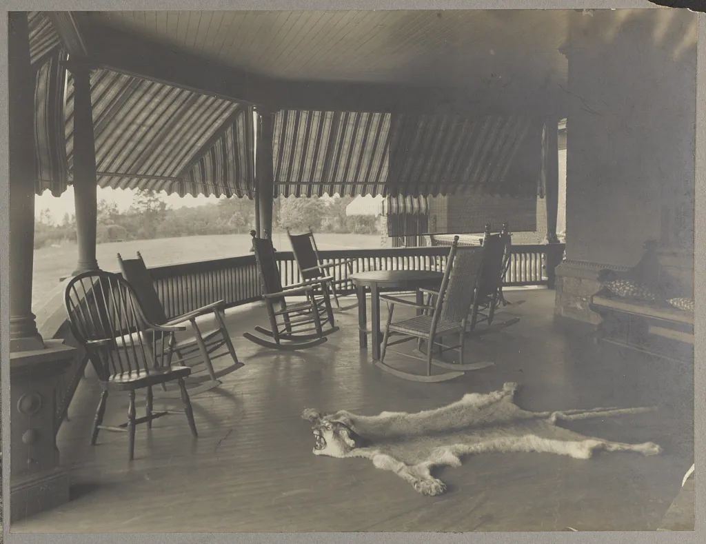 The broad piazza at Sagamore Hill with rocking chairs and a view toward Oyster Bay