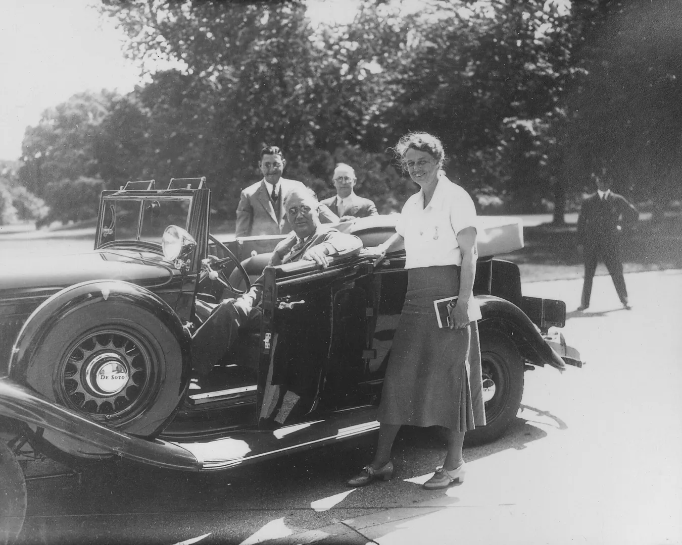 Franklin D. Roosevelt seated in an open car with Eleanor Roosevelt standing beside it in Washington, 1933