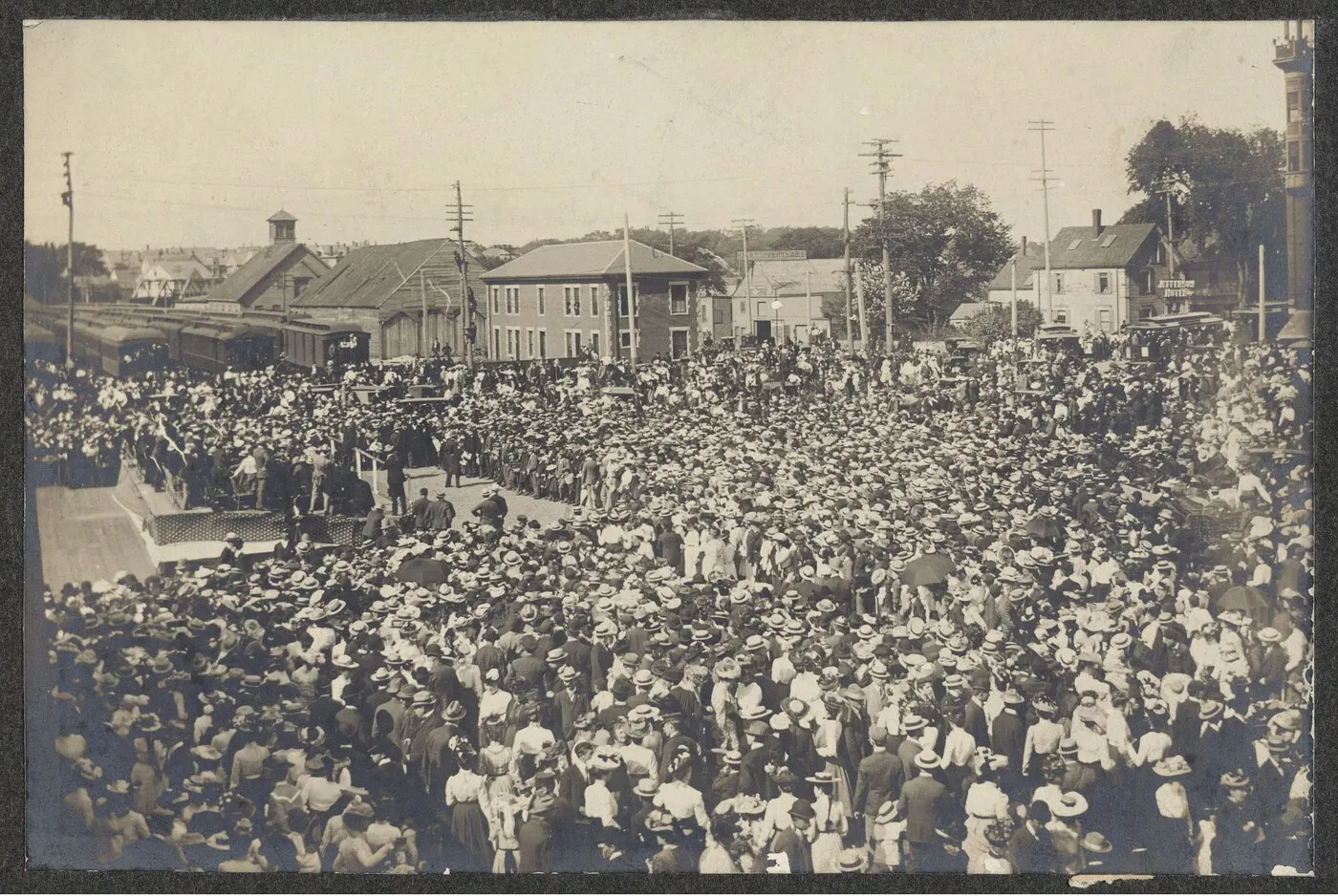 A vast crowd of citizens gathered in a town square to hear a speech