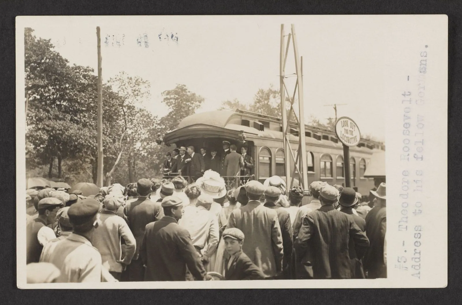 Theodore Roosevelt addressing a large crowd gathered around a rail car during the 1912 campaign