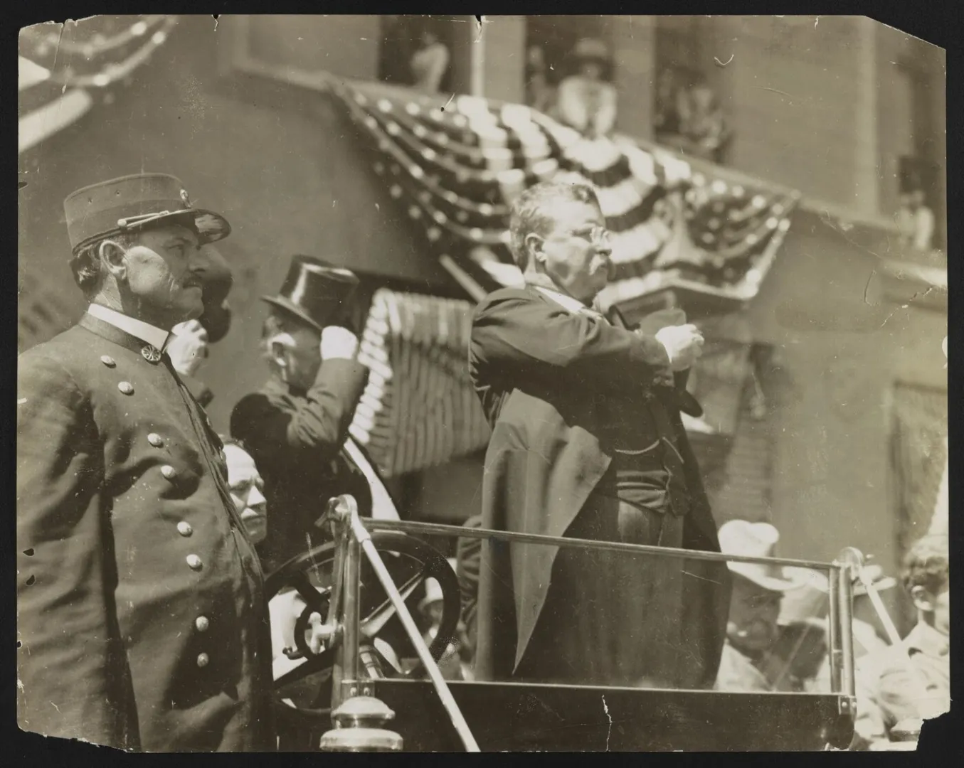 Theodore Roosevelt standing bareheaded with his hat held over his heart
