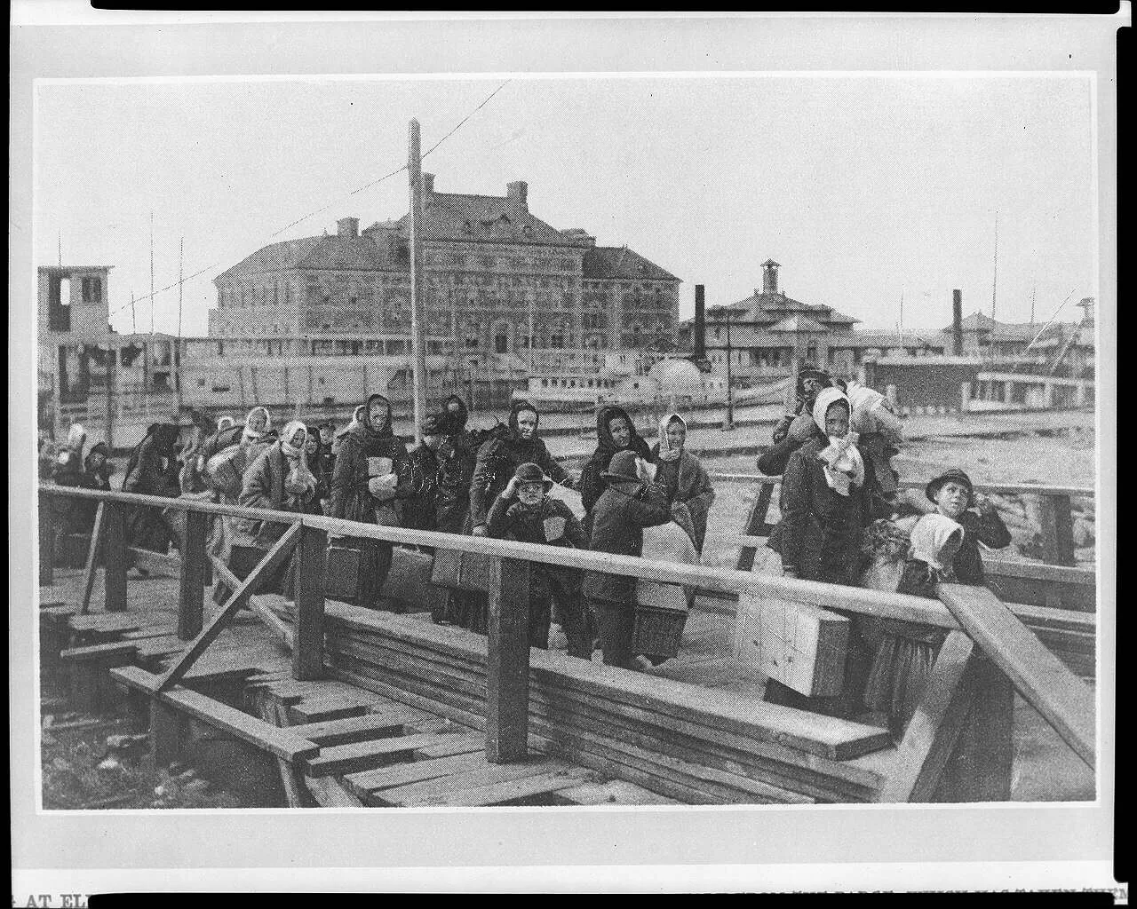 Immigrants walking down a gangway at Ellis Island in the early 1900s