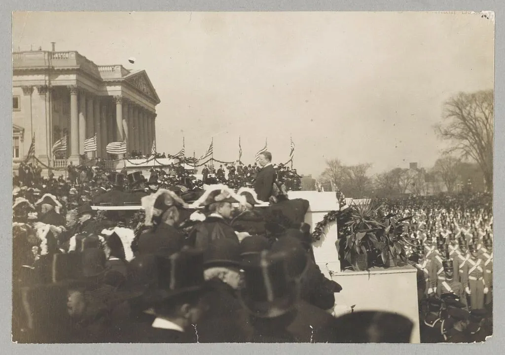 Theodore Roosevelt speaking from a platform to a large crowd