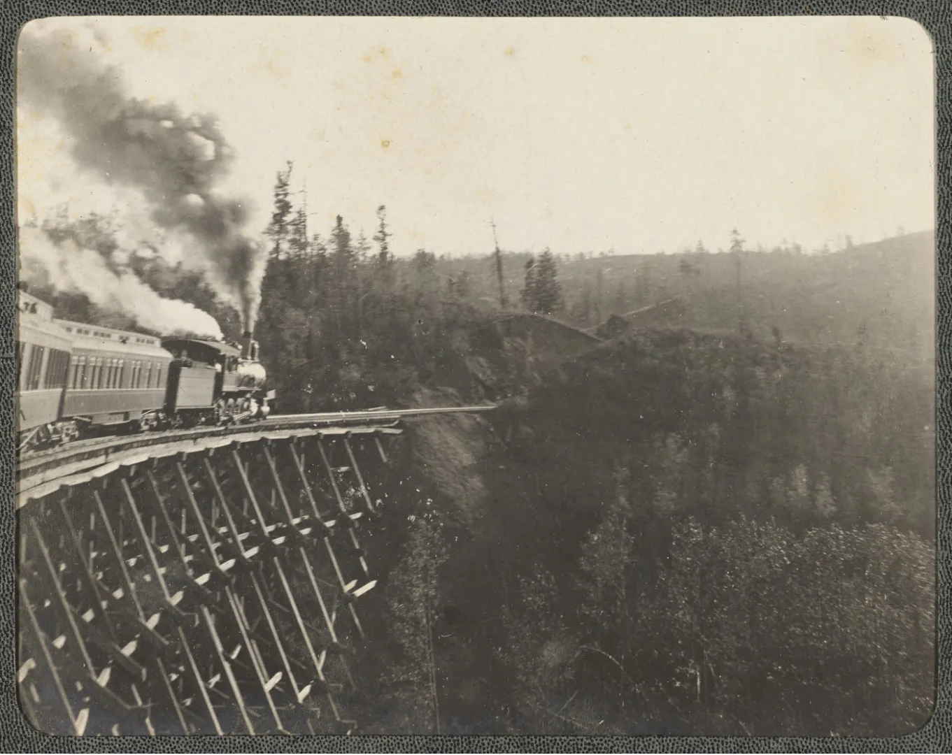 Theodore Roosevelt leaning from a train rear platform to address a large crowd during the 1900 campaign