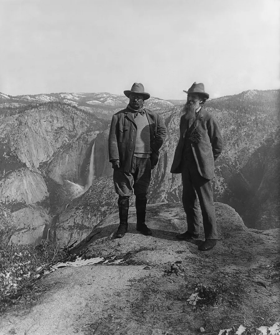 Theodore Roosevelt and John Muir standing on Glacier Point above Yosemite Valley with Yosemite Falls behind