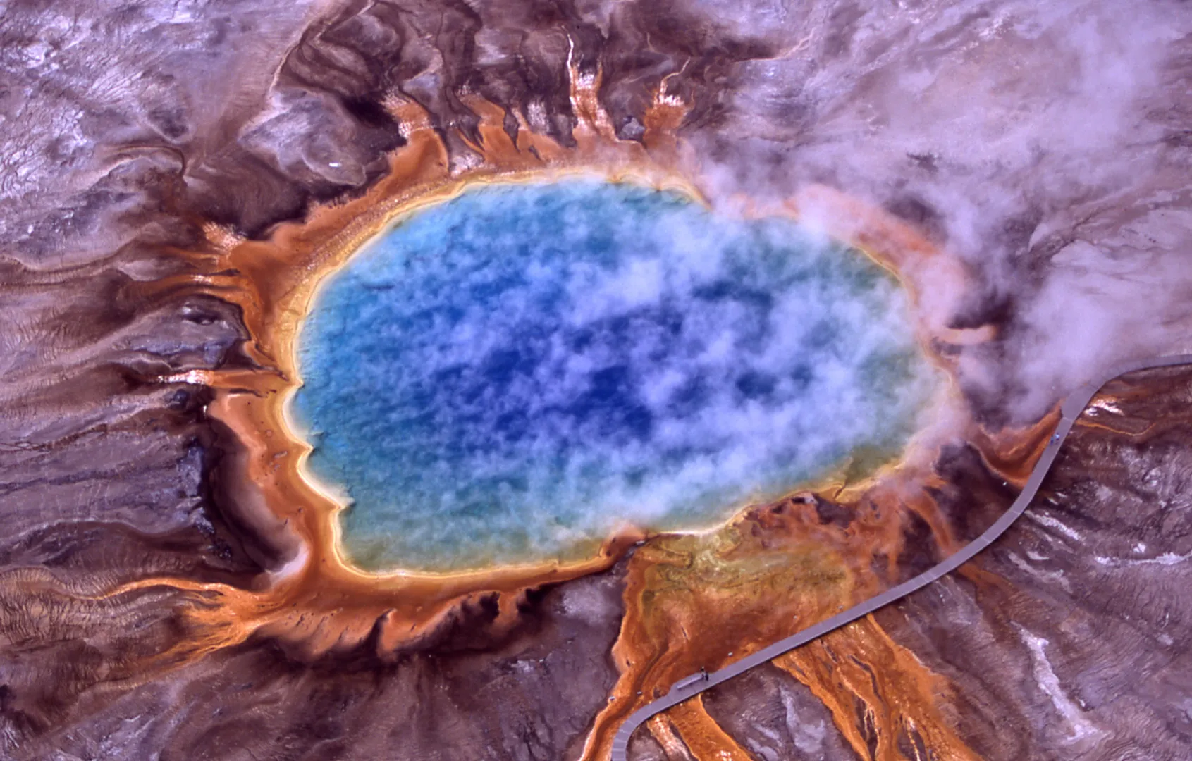 Aerial view of Grand Prismatic Spring in Yellowstone National Park, its blue centre ringed with orange bacterial mats