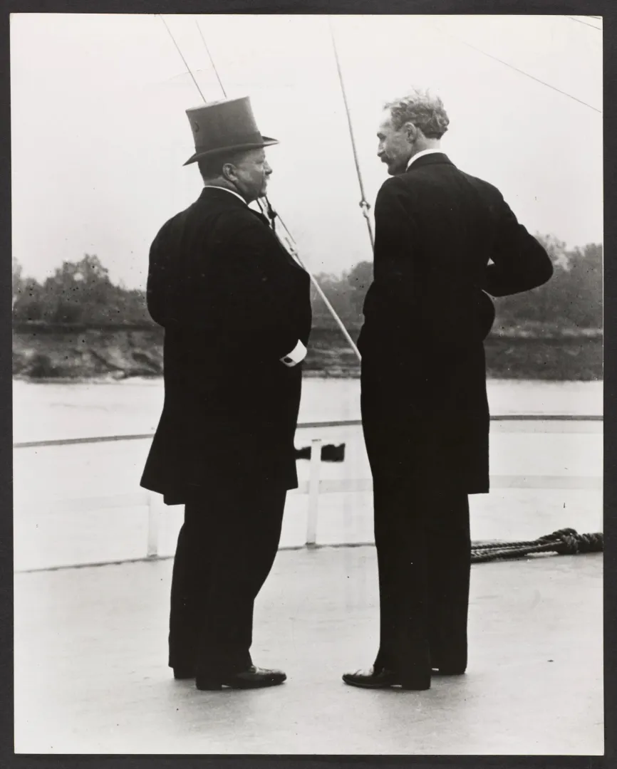 Theodore Roosevelt and Chief Forester Gifford Pinchot standing on a boat deck beside a river