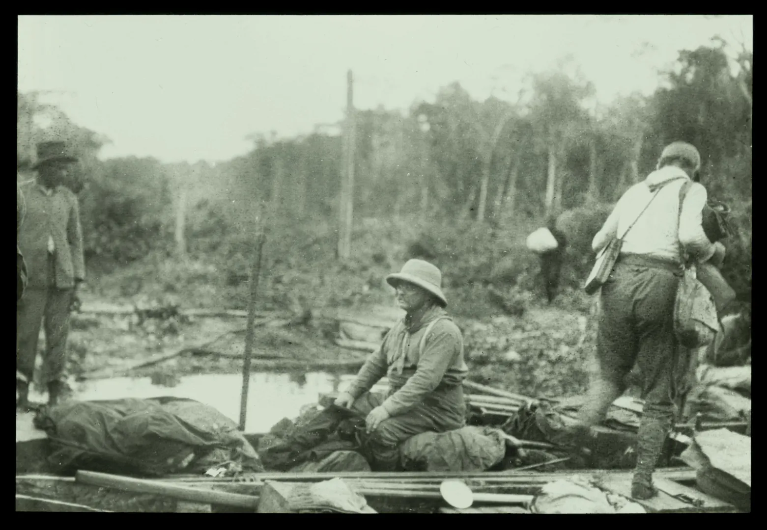 Theodore Roosevelt and expedition members seated in a boat during the South American expedition