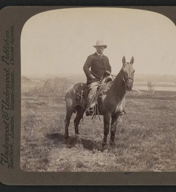 Theodore Roosevelt mounted on horseback on the open plains