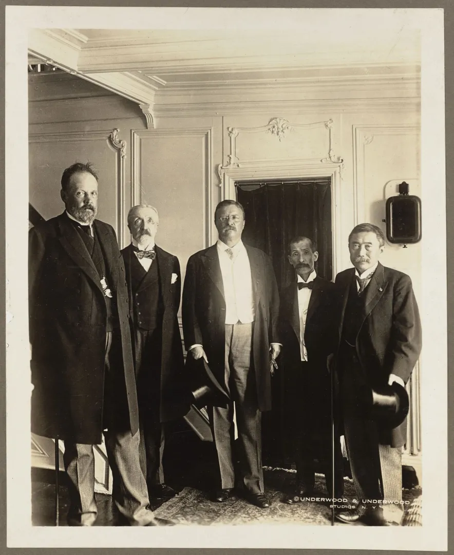 President Theodore Roosevelt standing with the Russian and Japanese envoys to the 1905 Portsmouth Peace Conference