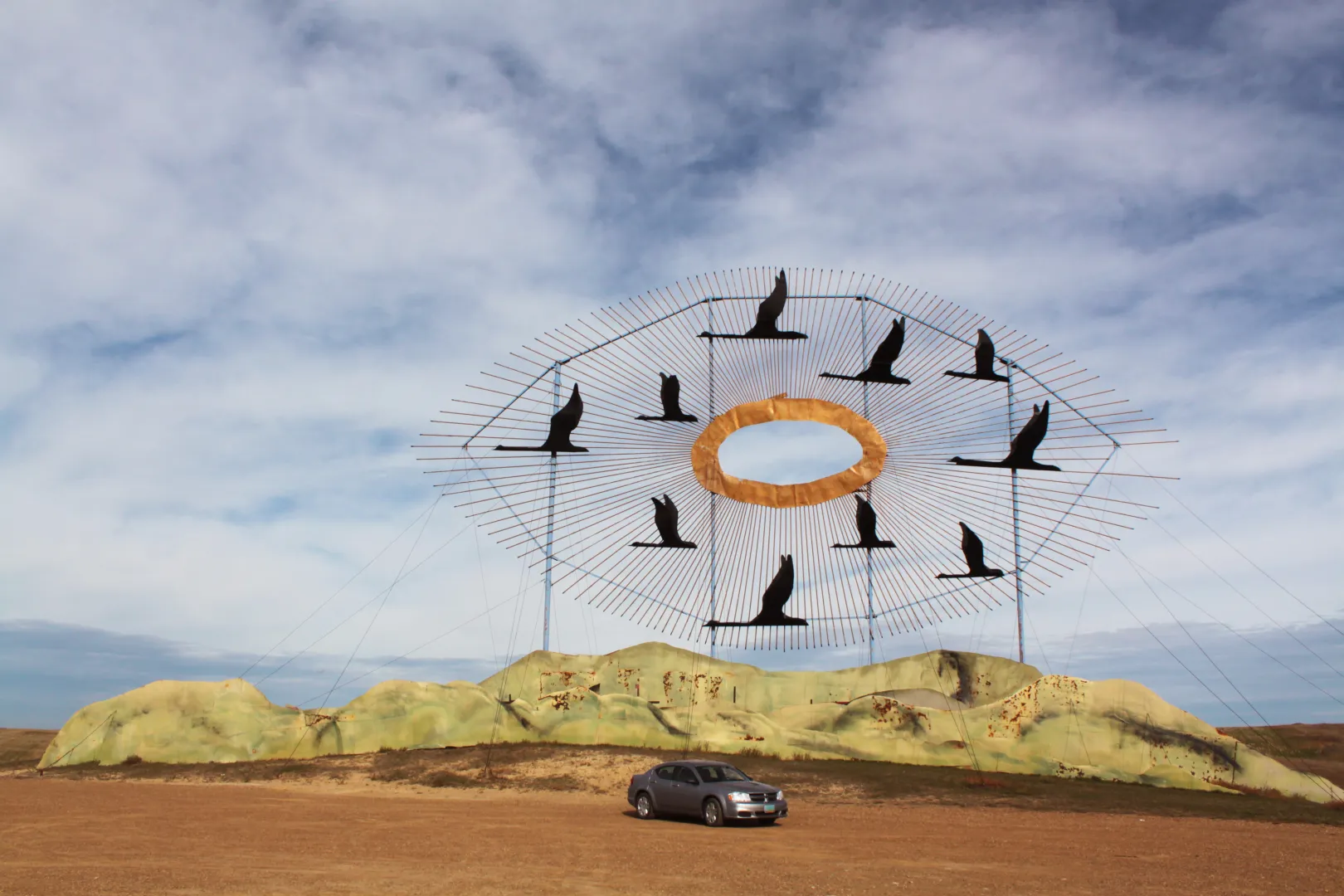 Geese in Flight, the giant scrap metal sculpture at the north end of the Enchanted Highway, with a car parked below for scale