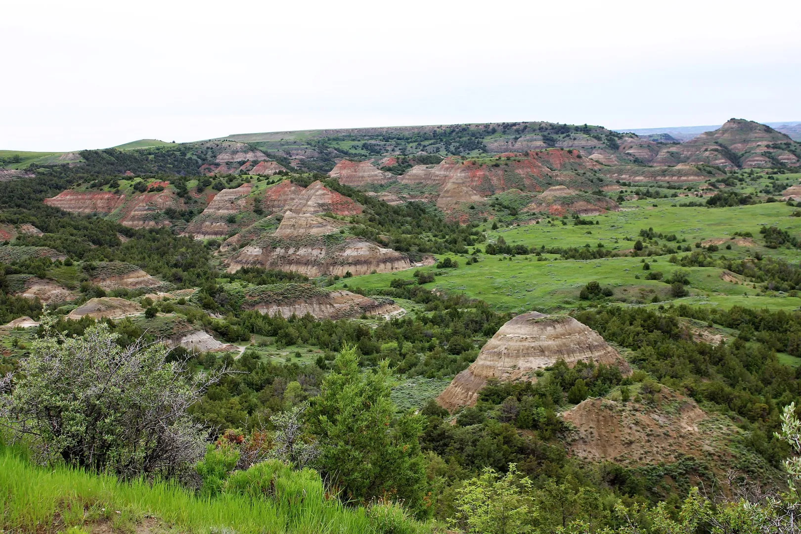 Colorful layered buttes striped with red, tan, and gray sediment at Painted Canyon in the North Dakota Badlands