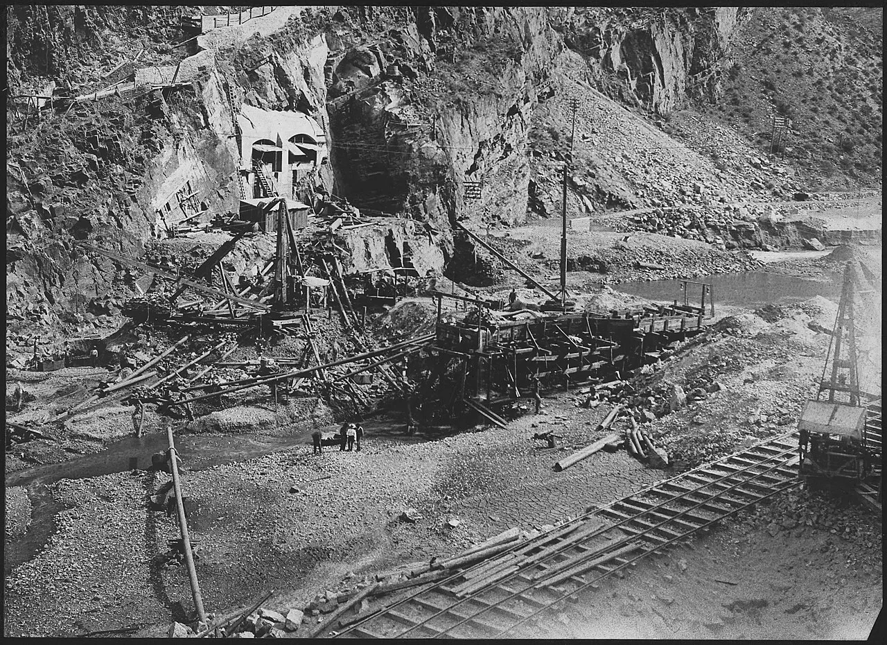 Roosevelt Dam construction site in a canyon with derricks, cableways and railroad tracks, circa 1906