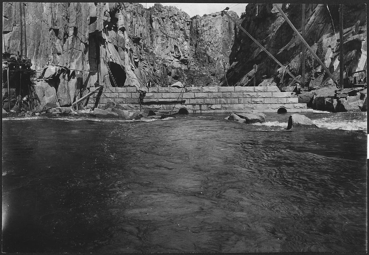 Masonry face of Pathfinder Dam holding back water in a rocky Wyoming canyon, 1907