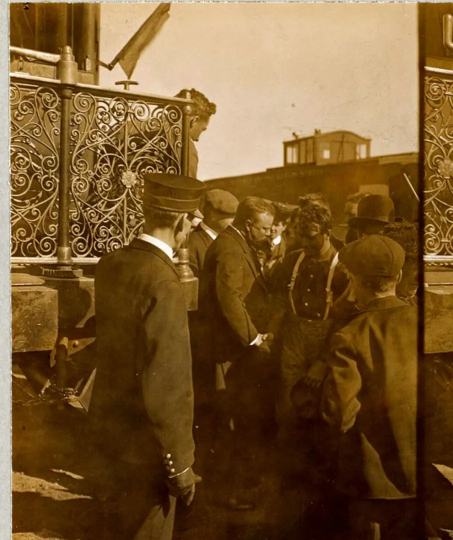 Theodore Roosevelt greeting working men on a platform