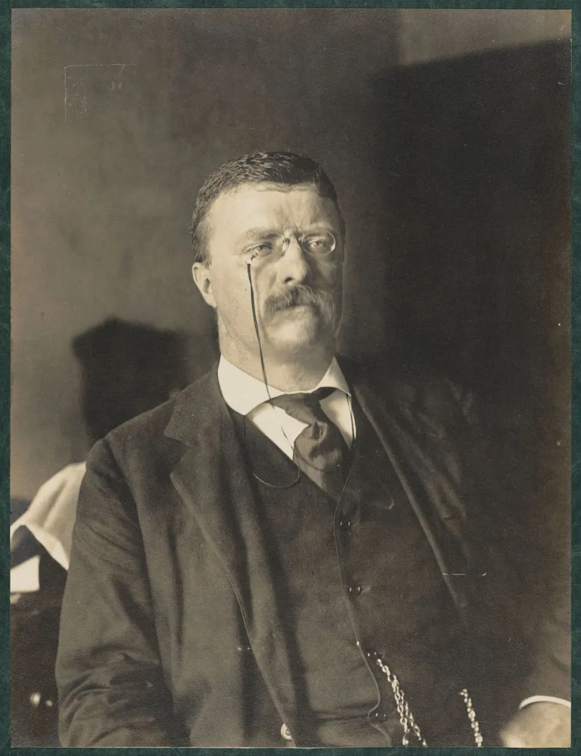 Theodore Roosevelt seated at his desk as Assistant Secretary of the Navy